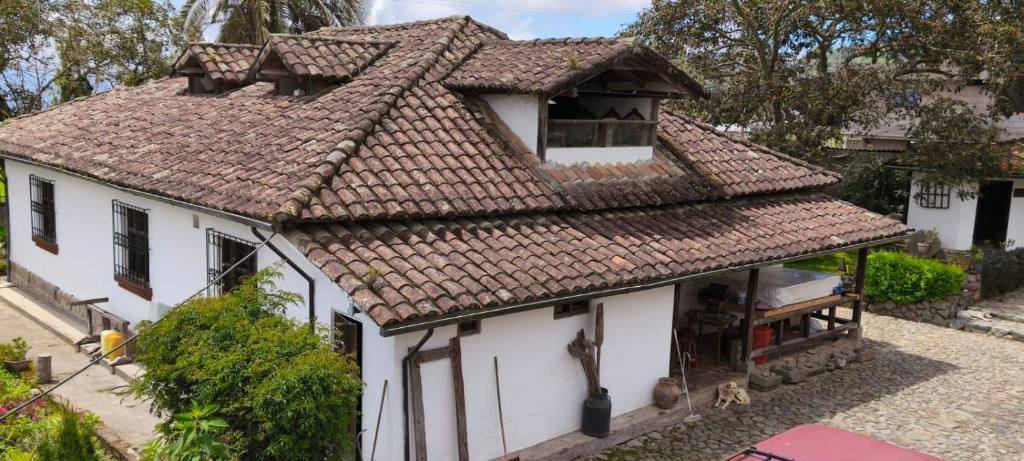 una antigua casa blanca con techo marrón en Lodge Chagras y Arrieros, 