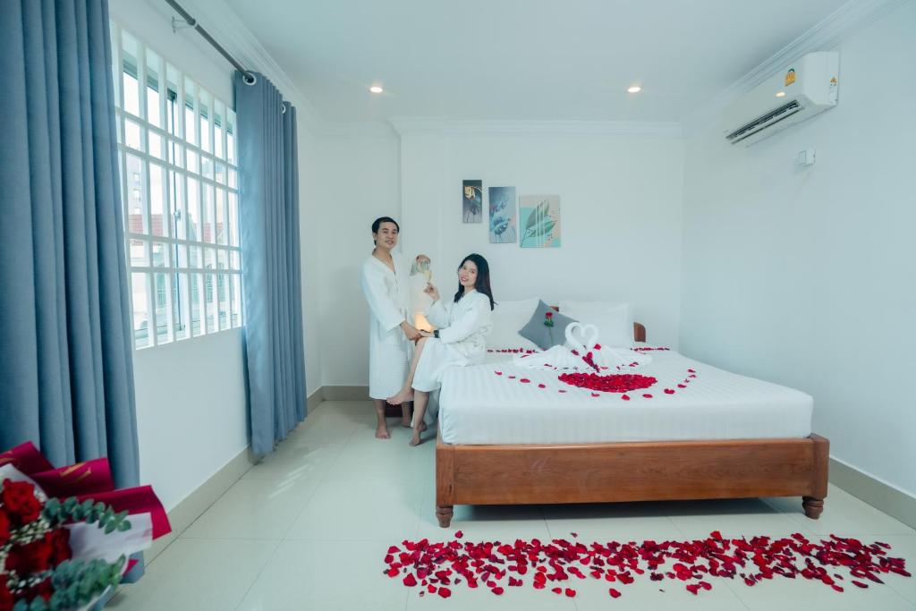 a bride and groom in a hotel room with a wedding cake at White Corner Hotel in Phnom Penh
