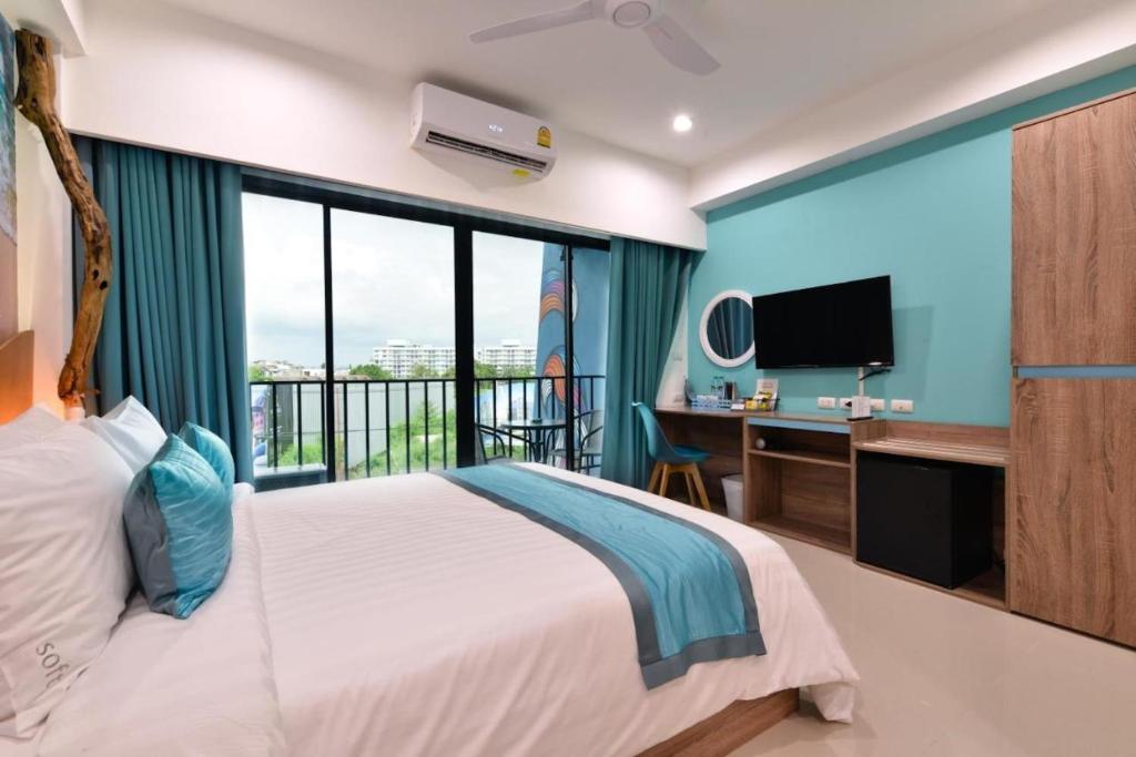 Jomtien Beach Market Place في جومتين بيتش: غرفة نوم بها سرير ومكتب وتلفزيون