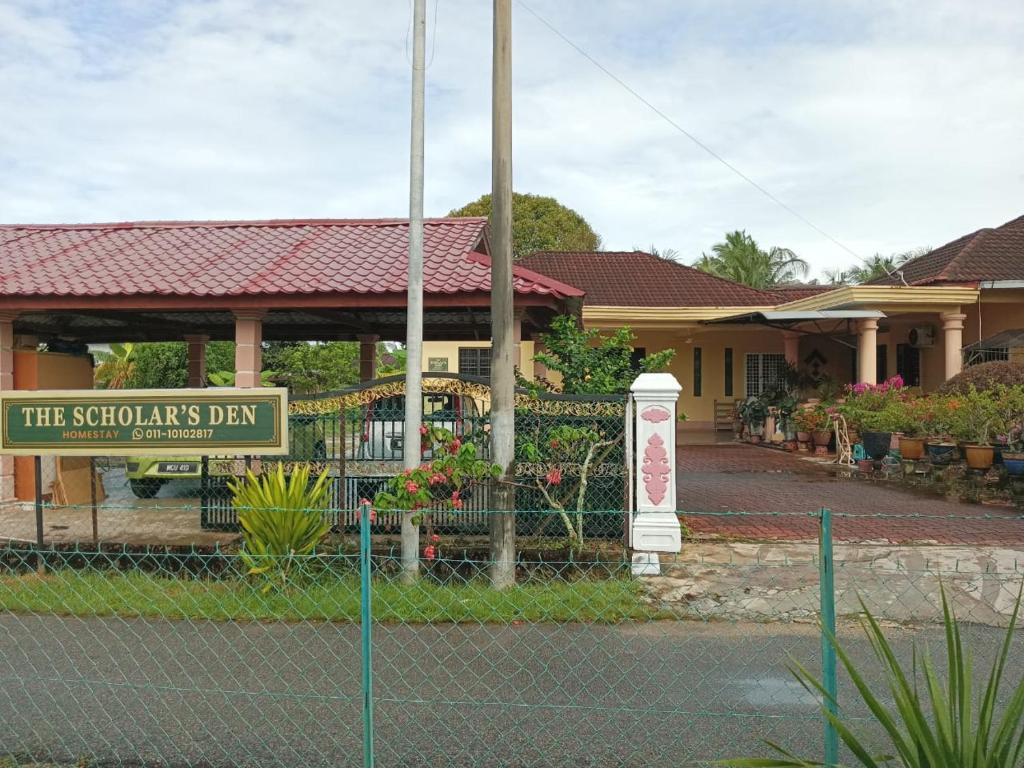 un cartel en una valla delante de una casa en The Scholar's Den Homestay, en Kampong Bukit Kechil