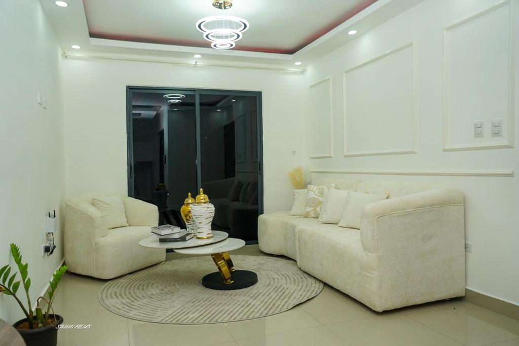 a living room with two white couches and a table at Penthouse Palmares SkyView in La Romana