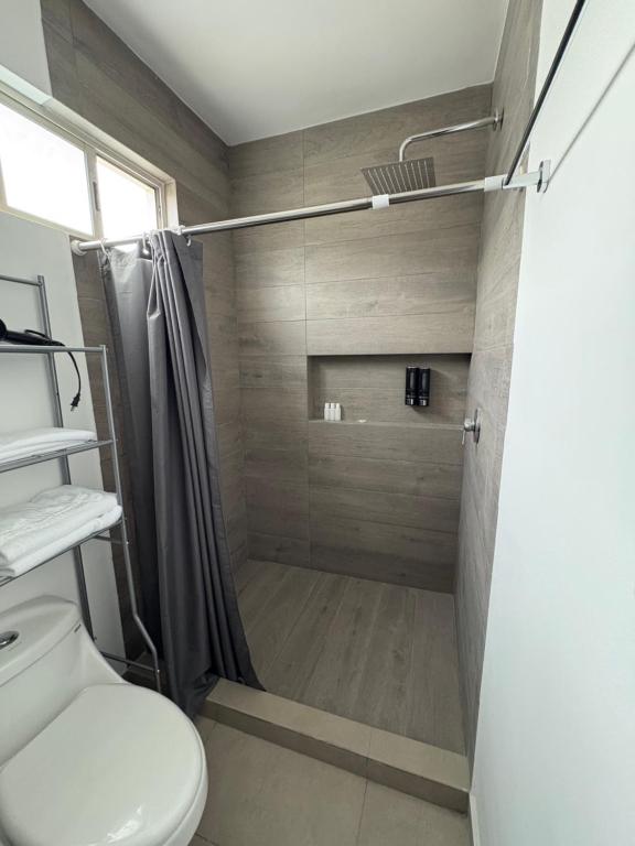 a bathroom with a shower and a toilet at Cuarto independiente frente al museo del desierto in Saltillo