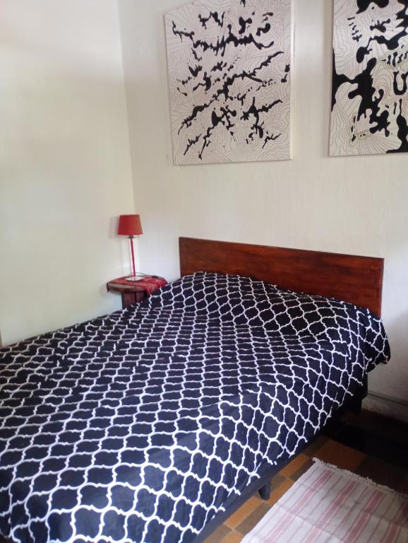 a bedroom with a bed with a black and white comforter at Centro de rio in Río Ceballos