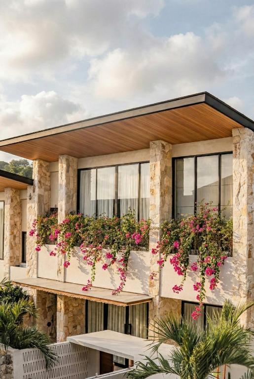 a building with flowers on the balconies at La Brava Bali I Private Luxury Villas in Bingin, Uluwatu in Uluwatu