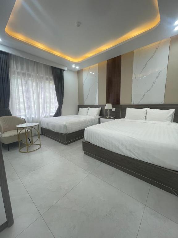 Six Brothers Boutique Hotel في Kon Rung (1): غرفة فندقية تحتوي على سريرين وأريكة