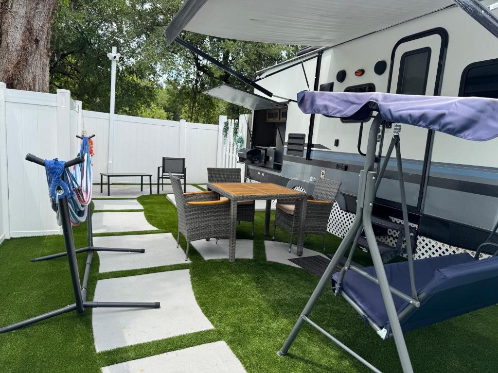 un camping-car avec une table, des chaises et une table de pique-nique dans l'établissement Oasis rodante, à Tampa