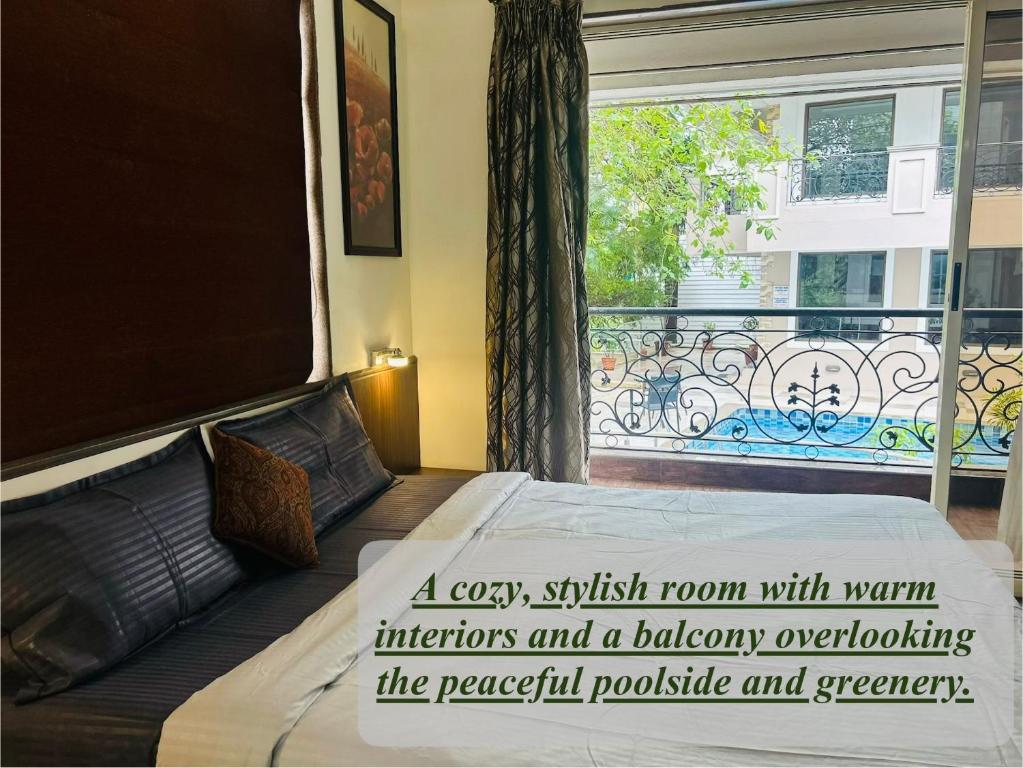 a bedroom with a bed and a window with a balcony overflowing the peaceful possible at Marvella Stays in Anjuna