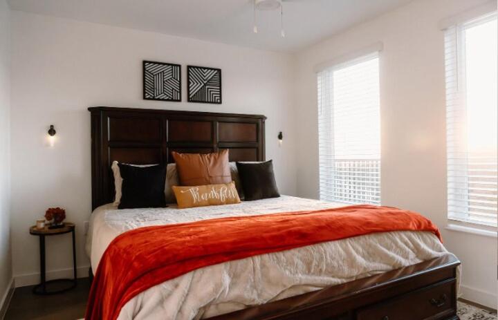 a bedroom with a large bed with orange blanket at Luxury Mountain Views at Prime Location Huntsville in Huntsville