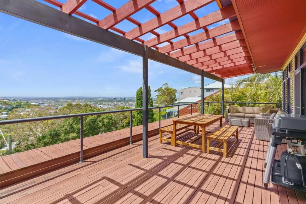 a deck with a wooden table and a bench at Hilltop Hideaway Family Escape in Merewether