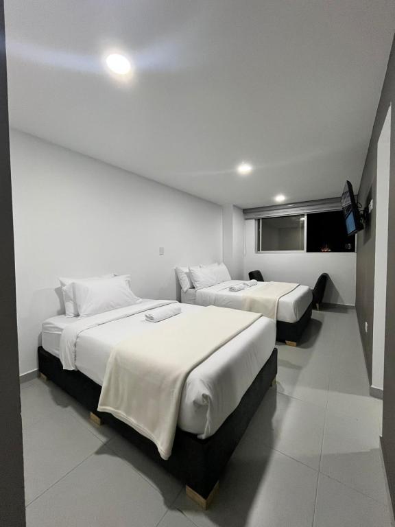a bedroom with two beds and a flat screen tv at Apartamento moderno, central, inteligente y totalmente equipado in Duitama