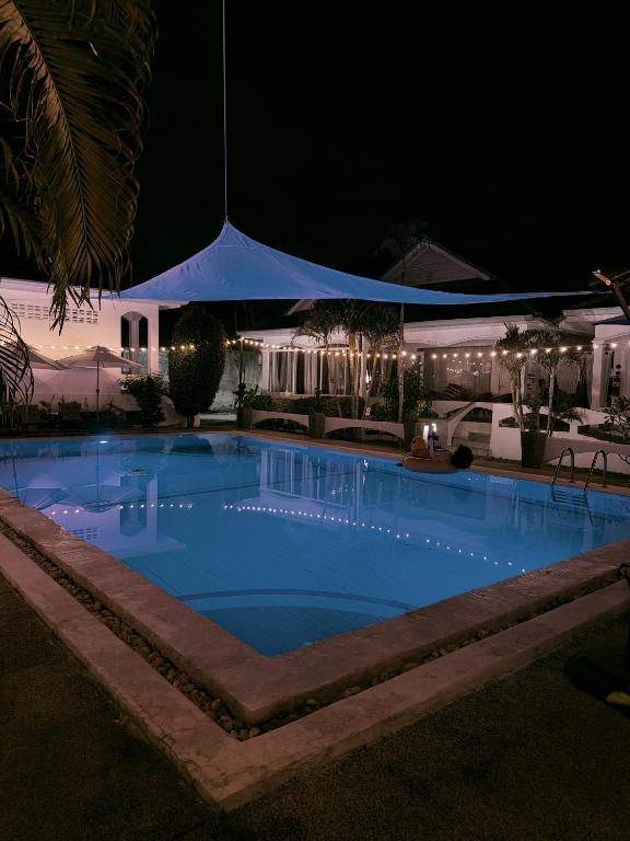 a large swimming pool at night at The Rai Resort Rawai - Pool & Garden in Ban Bang Chak