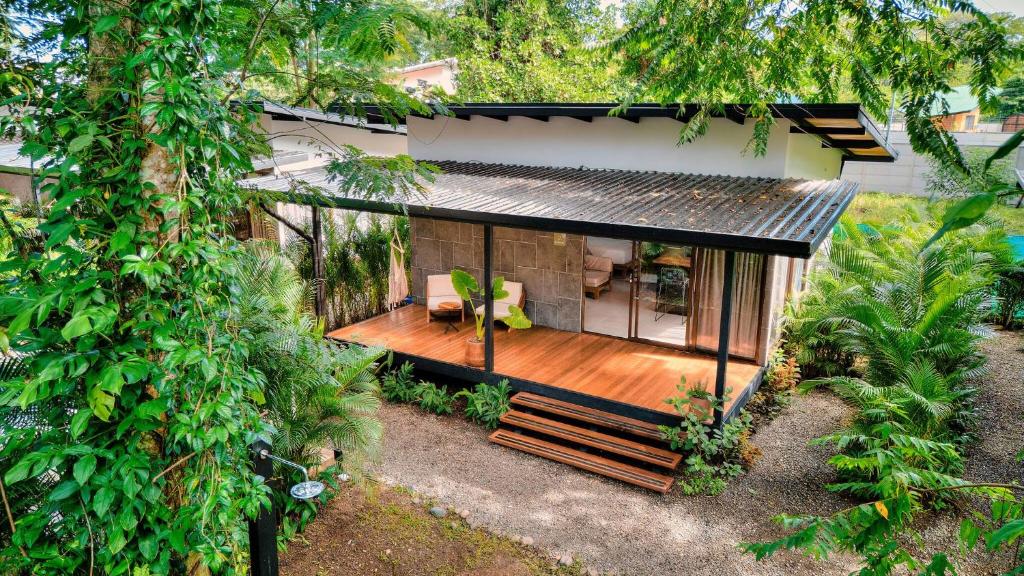 a house with a wooden deck in the yard at Salt n Pepper - Rosemary Villa with shared Pool - Adults Only in Puerto Viejo