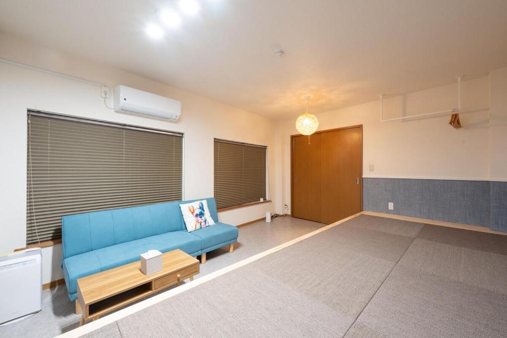 a living room with a blue couch in a room at NAGI setouchi in Takamatsu