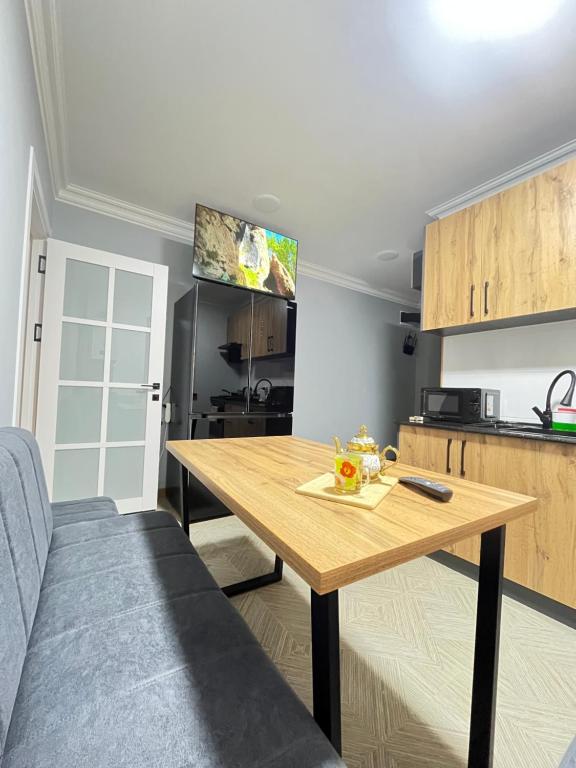 a kitchen with a wooden table in a room at Apartment lux in Samarkand