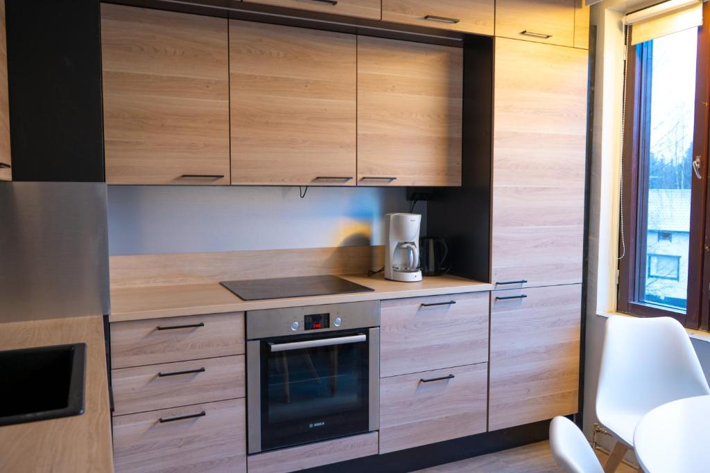 a kitchen with wooden cabinets and a stove at Apartment 55m2 in Kemijärvi 