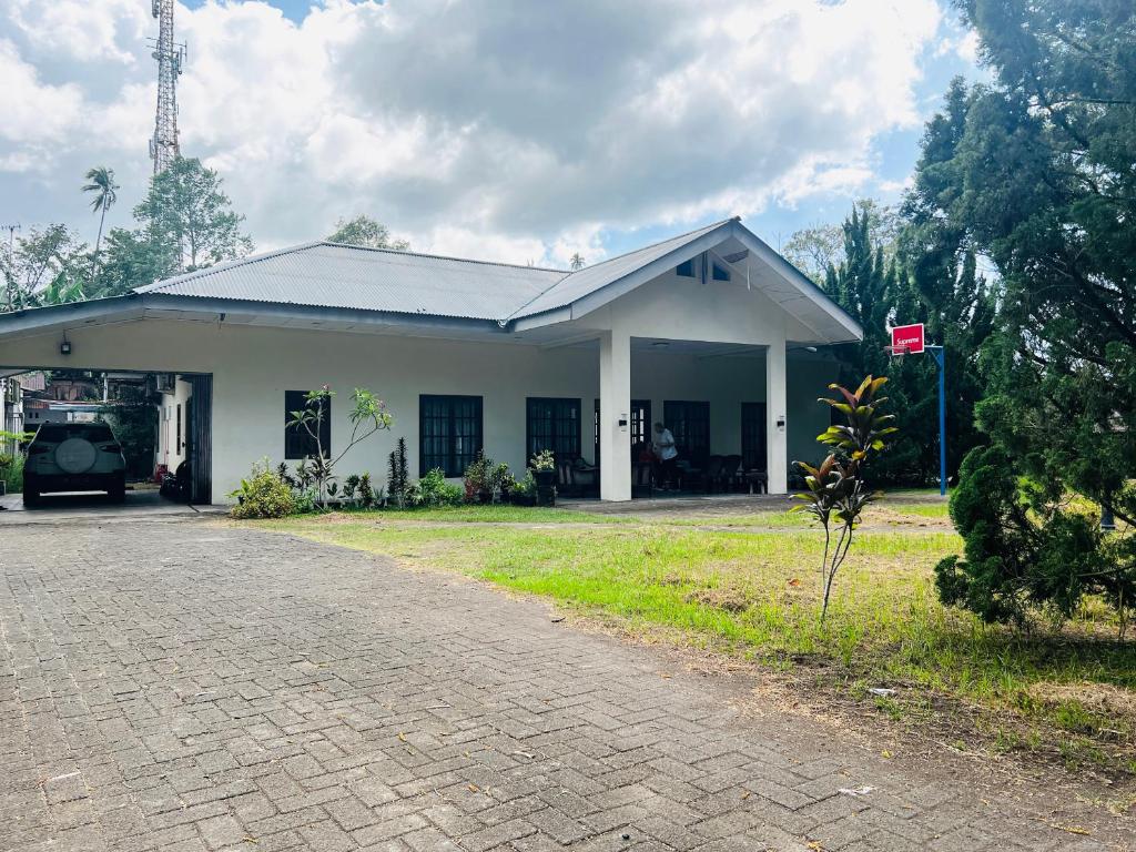 Juni Residence في Pineleng: مبنى صغير أبيض اللون أمامه طريق