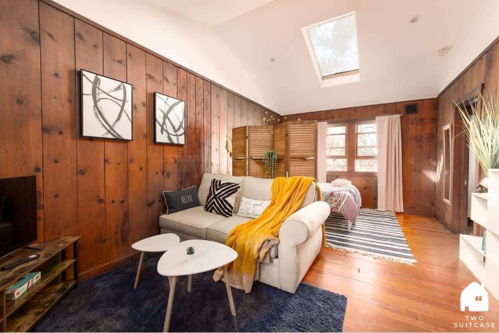 a living room with a couch and a table at Charming Garden Cottage & Walk to UC & BART & Parking in Berkeley