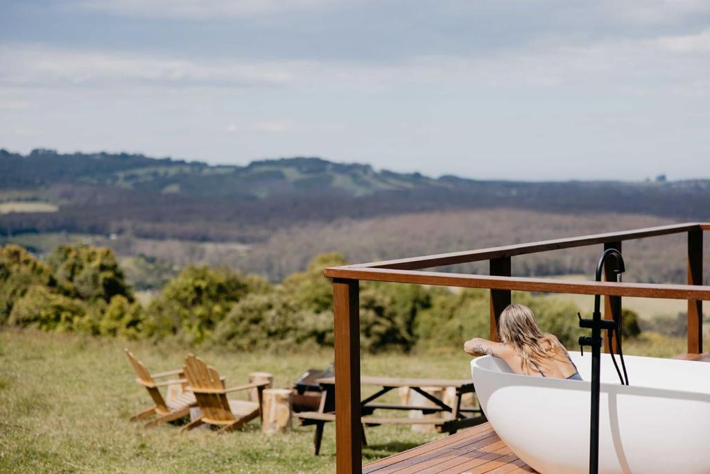 a woman sitting in a bath tub on a deck at Tiny Oscar in Robertson