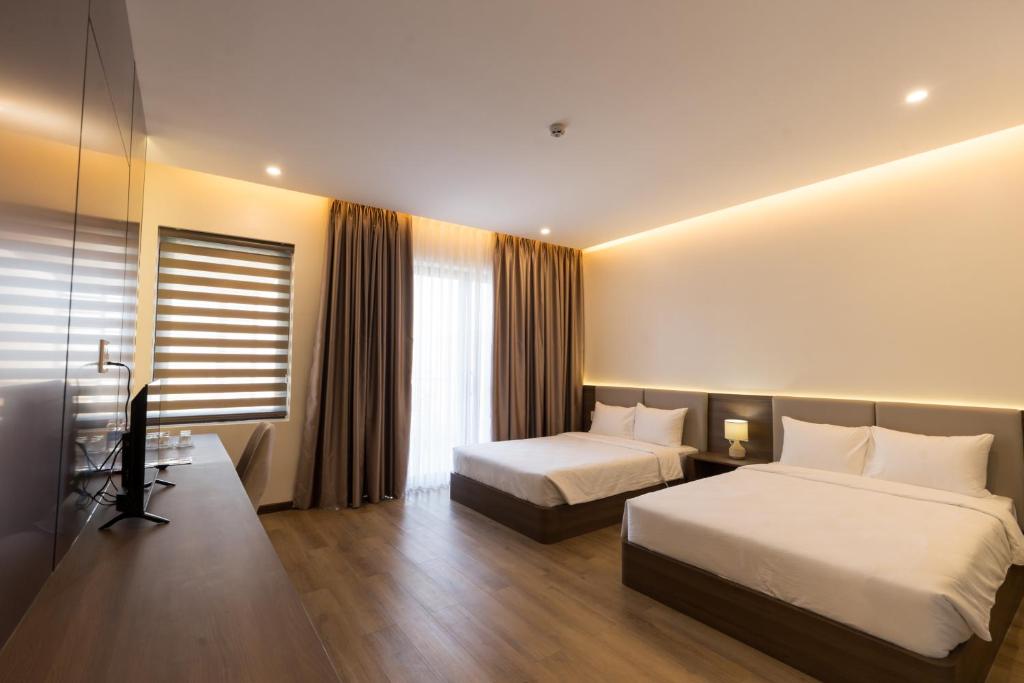 Ένα ή περισσότερα κρεβάτια σε δωμάτιο στο Adalie Pleiku Hotel