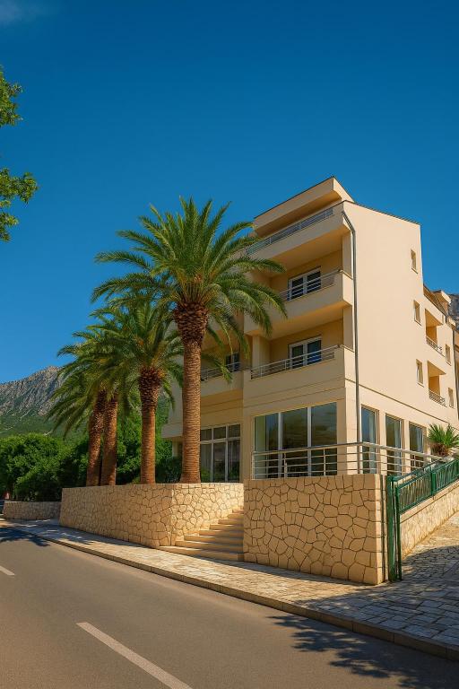 a building with palm trees on the side of the road at Hotel Neptun Gradac in Gradac