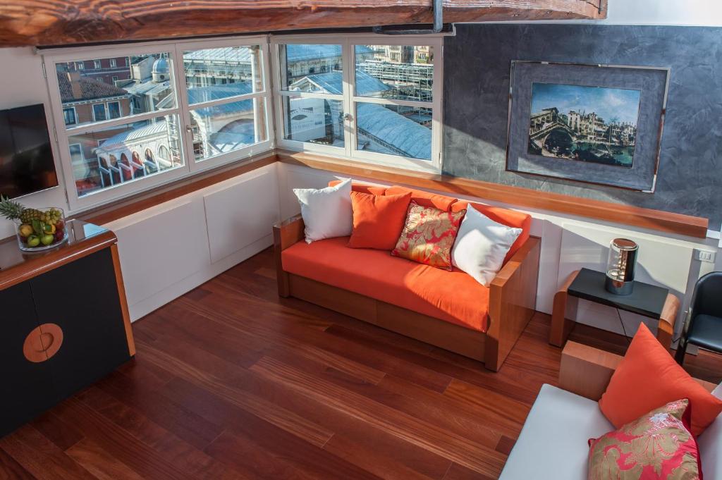 a living room with a couch and two windows at Hotel Rialto in Venice