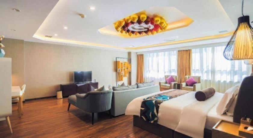a hotel room with a large bed and a living room at James Joyce Coffetel Jilin Railway Station Fortune Plaza in Jilin