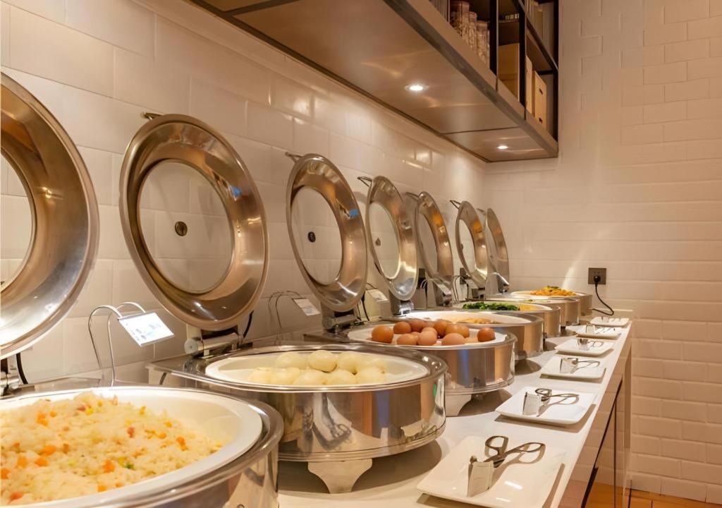 una fila de fregaderos en una línea de buffet de comida en Echarm Hotel Tai'an Taishan Tianwai Village Hongmen, en Tai'an