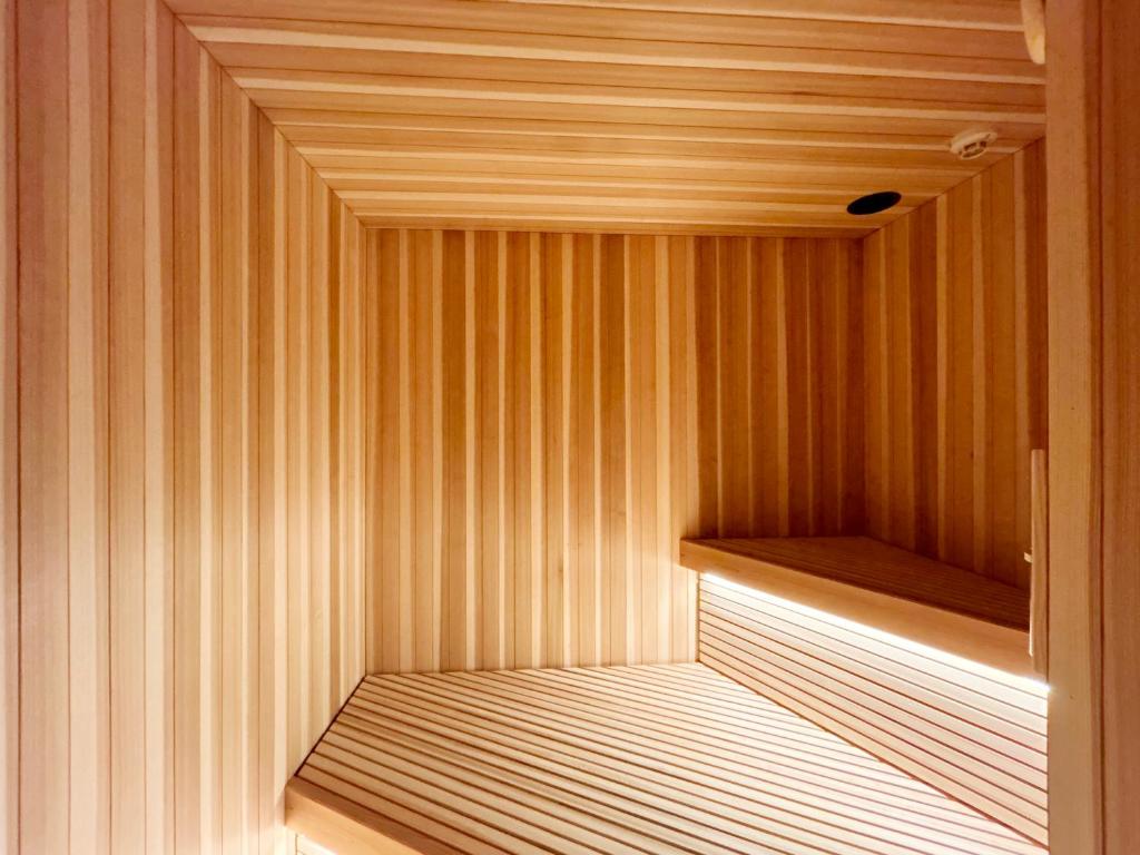 a sauna with wood paneled walls and a wooden shelf at MINI HOTEL totonoi ロウリュ式サウナのある静かな平屋 in Shimonoseki