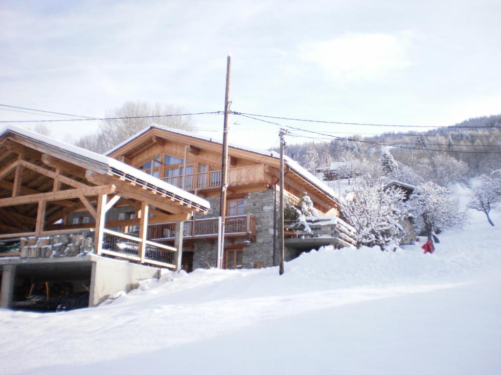 una cabaña de madera en la nieve con nieve en Les Deux Tetes 2 Chez Fifine, en Arc 1600