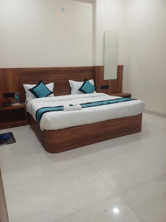 a bedroom with a large bed with blue pillows at Hotel Soni Indore in Indore