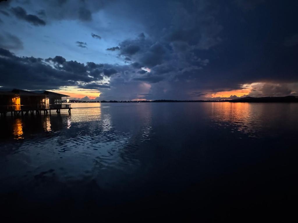 a sunset over a large body of water with a dock at Kthorm Nesat Koh Kong in Phumĭ Stœ̆ng Vêng