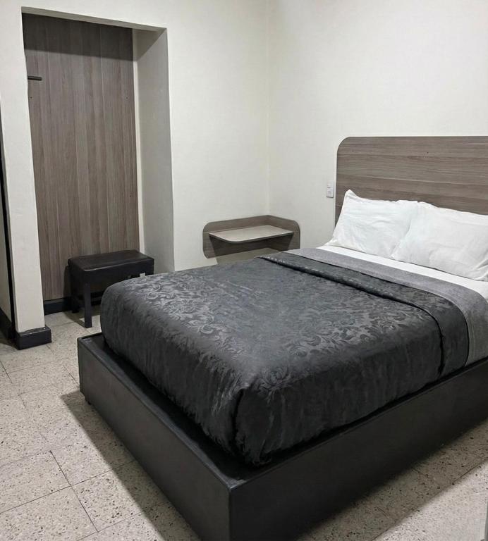 ein Schlafzimmer mit einem großen Bett und zwei Tischen in der Unterkunft Hotel Descanso in Santa Ana Chiautempan