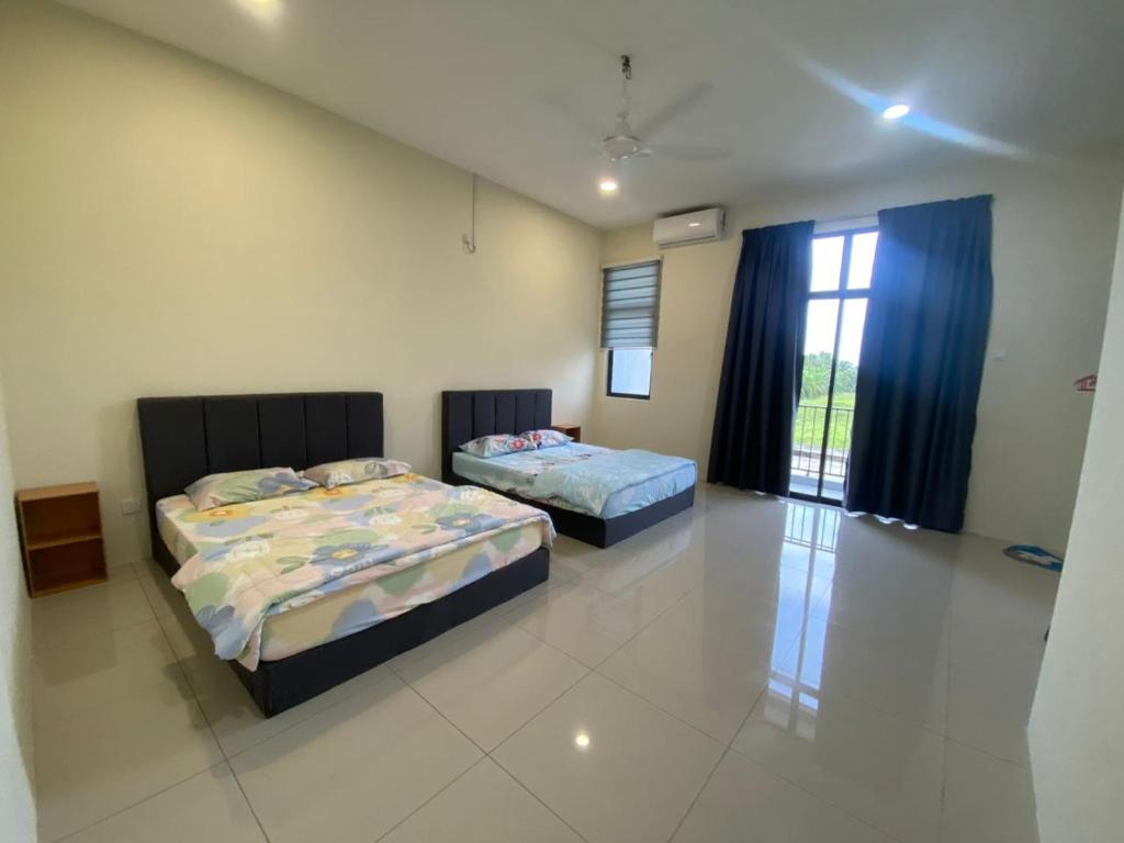Un dormitorio con dos camas y una ventana. en 96 HomeStay Sungai Besar, en Sungai Besar