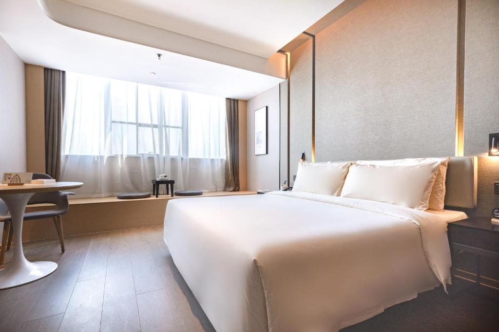 Ένα ή περισσότερα κρεβάτια σε δωμάτιο στο Atour Hotel (Wuhan Qingshan Peace Park)