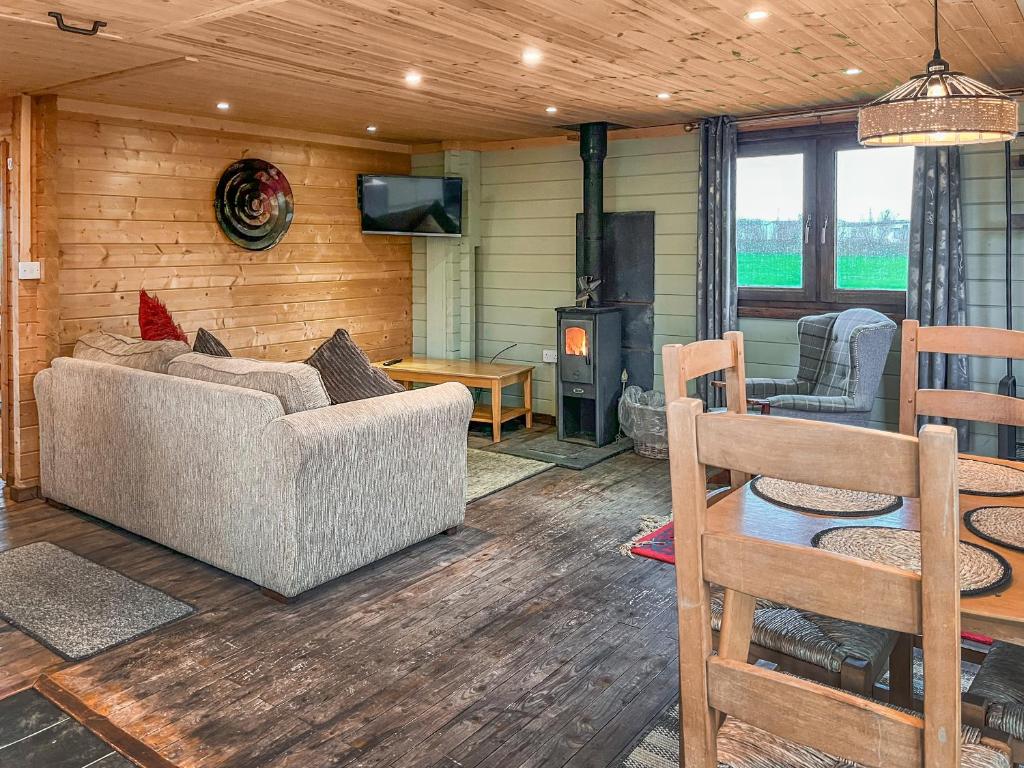 een woonkamer met een bank en een open haard bij The Lodge - Uk50721 in Aldbrough