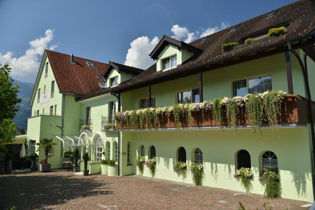 a green building with plants on the side of it at Hotel Hofbalzers in Balzers