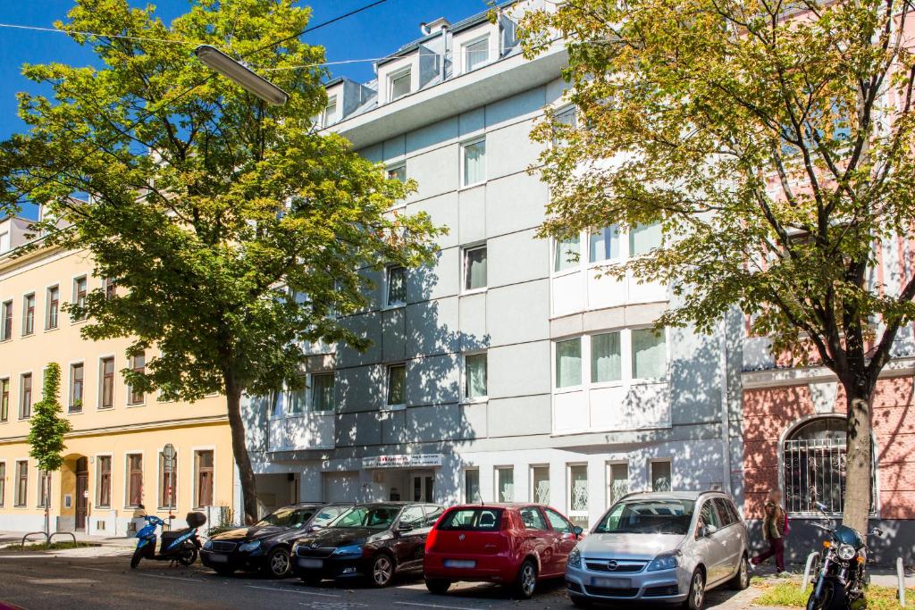 ein weißes Gebäude mit davor geparkt in der Unterkunft Residenz Donaucity in Wien