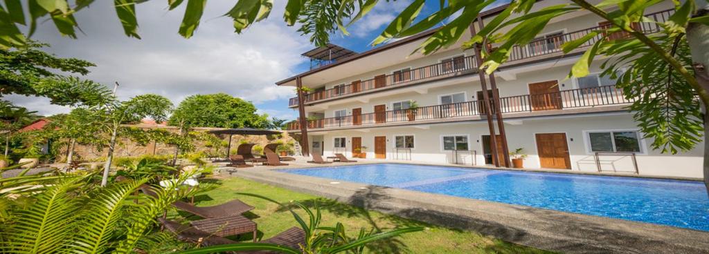 a swimming pool in front of a building at Bayview Garden Resort in Tagbilaran City