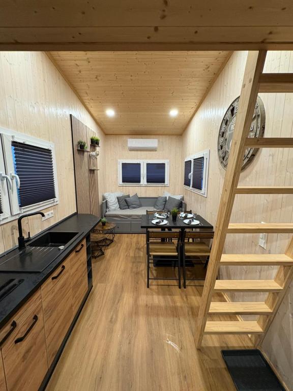 a kitchen and living room with a staircase in a tiny house at KE-Tiny Haus Paulchen in Oerlenbach