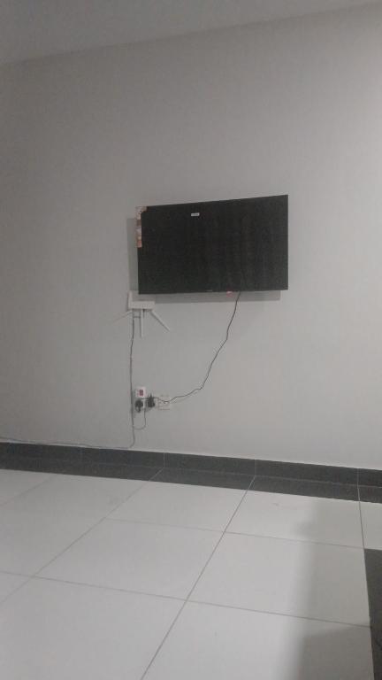 a television on a white wall in a room at Mikes apartment in Mombasa
