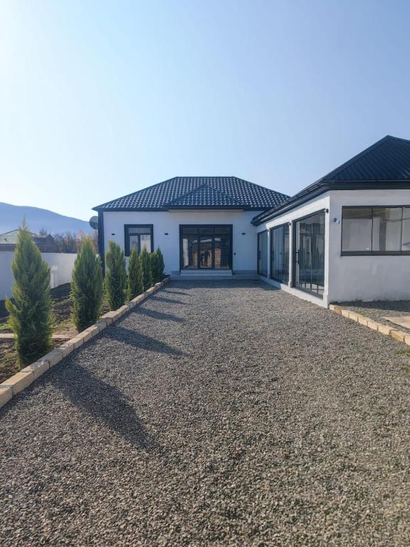 a house with a gravel driveway in front of it at Quba Mountain View Villa with Heated Pool in Quba