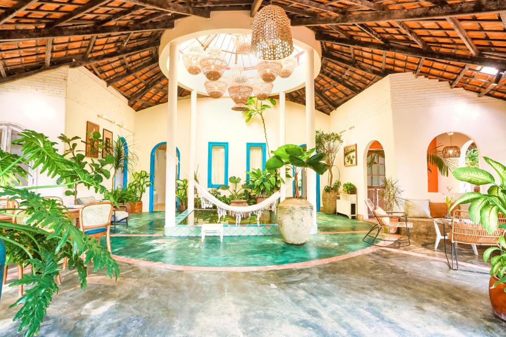 Lara Homestay في Ấp Gò Dinh: غرفة كبيرة مع طاولة وكراسي ونباتات