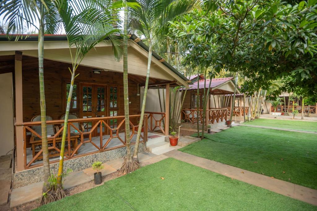 a house with a green lawn in front of it at BOHOA Beach Resort Palolem in Palolem