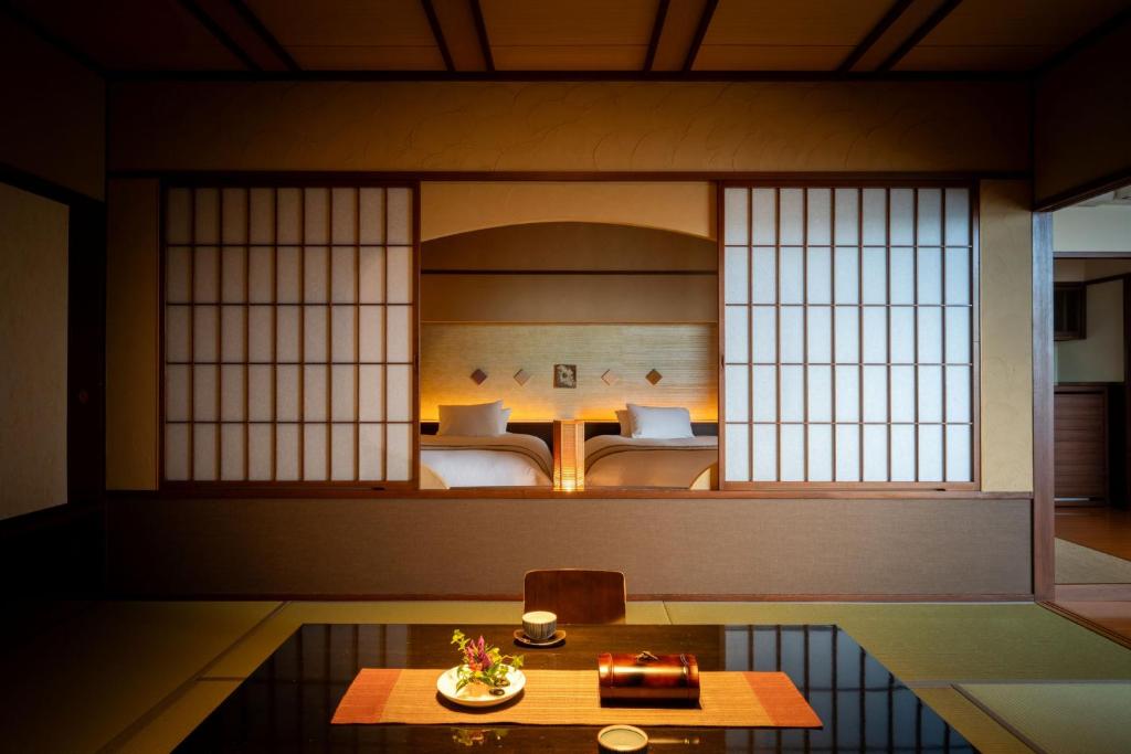 une chambre avec une pièce avec deux lits et une table dans l'établissement Takinoyu Hotel, à Tendō