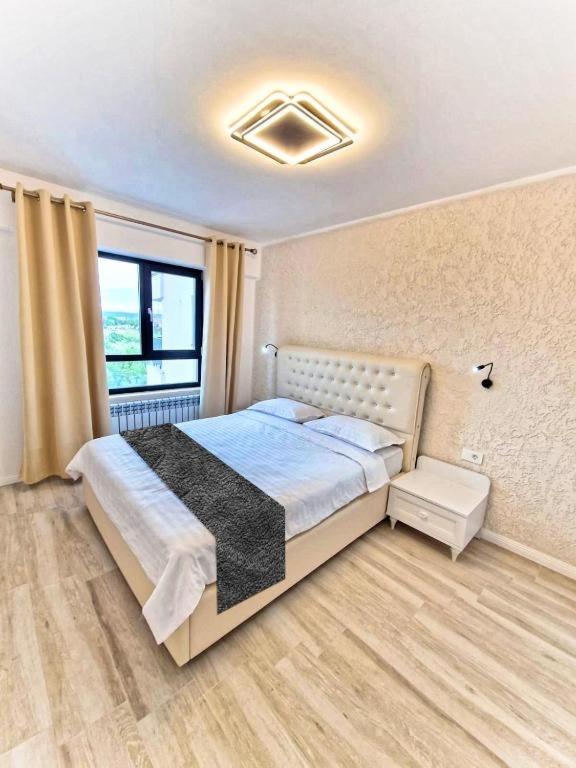 a bedroom with a bed and a large window at Apart-hotel Magestic EVN Airport in Pʼarakʼar