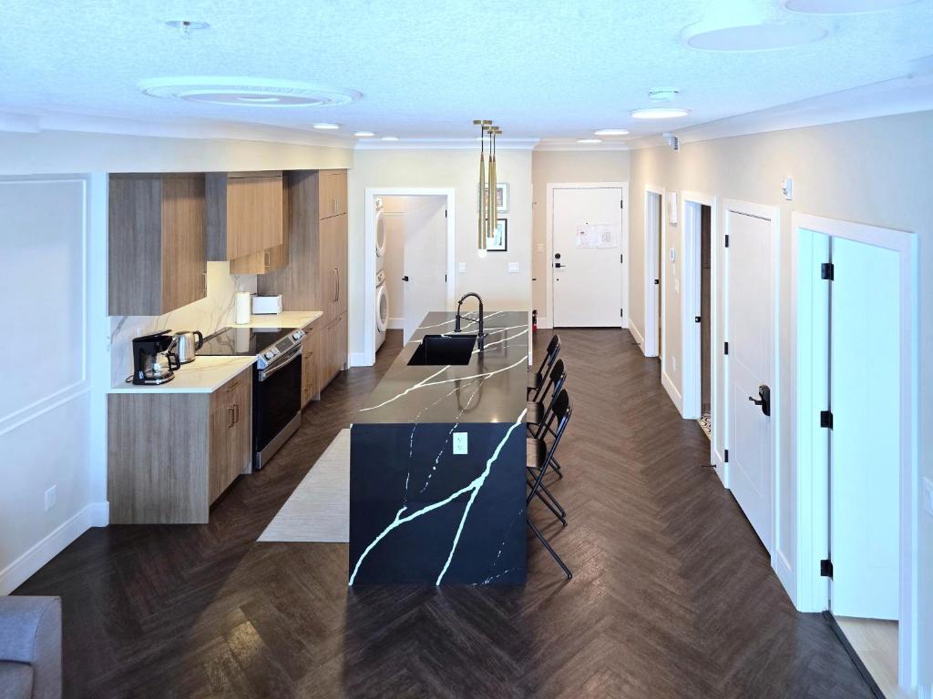 a kitchen with a table and chairs in a room at Family Stylish 2BR Condo with City View, DT, Balcony, Free Parking & In-Suite Laundry! in Calgary