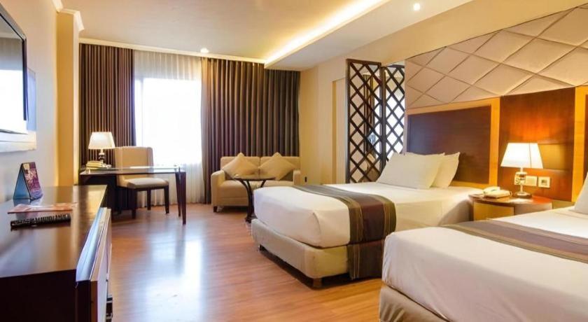 Postel nebo postele na pokoji v ubytování Regent's Park Hotel at Kayutangan Malang