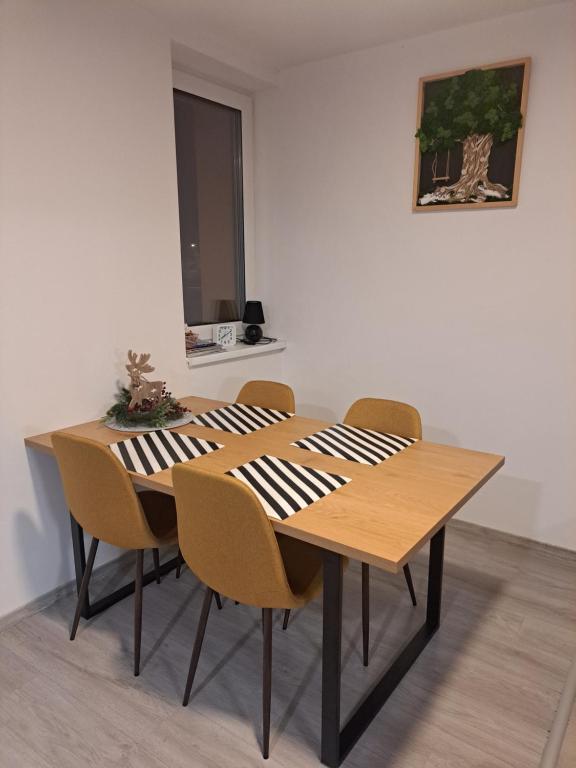 una mesa de madera con sillas en una habitación en Budget Apartment KNM5, en Kysucké Nové Mesto
