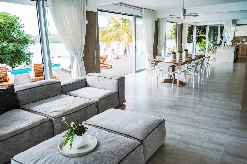 Villa Mariposa Ocean Front Mansion with Infinity Pool في غانيكا: غرفة معيشة بها أريكة وطاولة