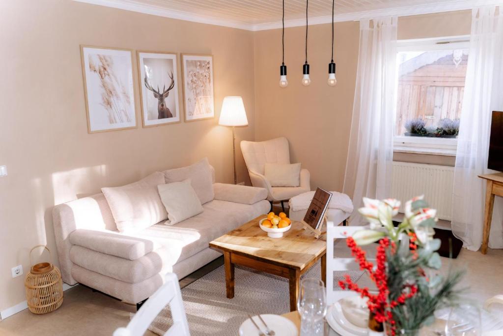 een woonkamer met een witte bank en een tafel bij Ferienwohnung Weideblick Gänsberg in Blaibach